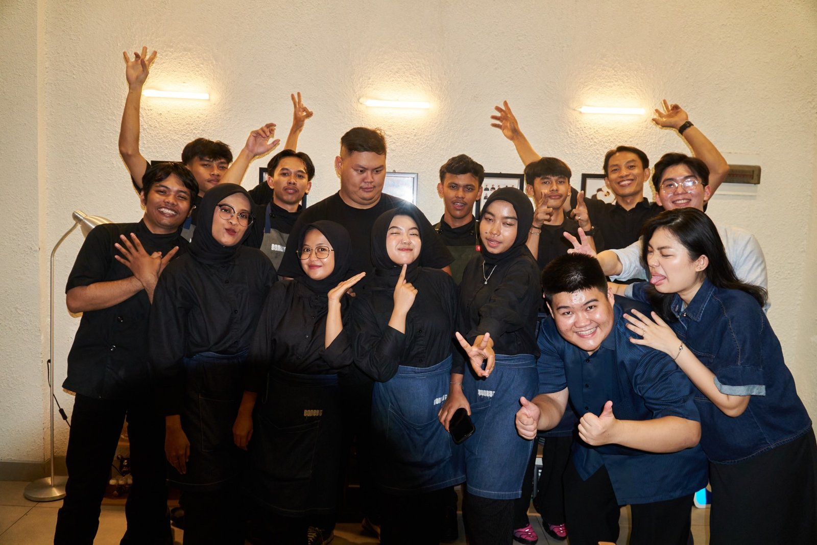 The BONBU team laughing together outside the restaurant, holding a GrabFood award